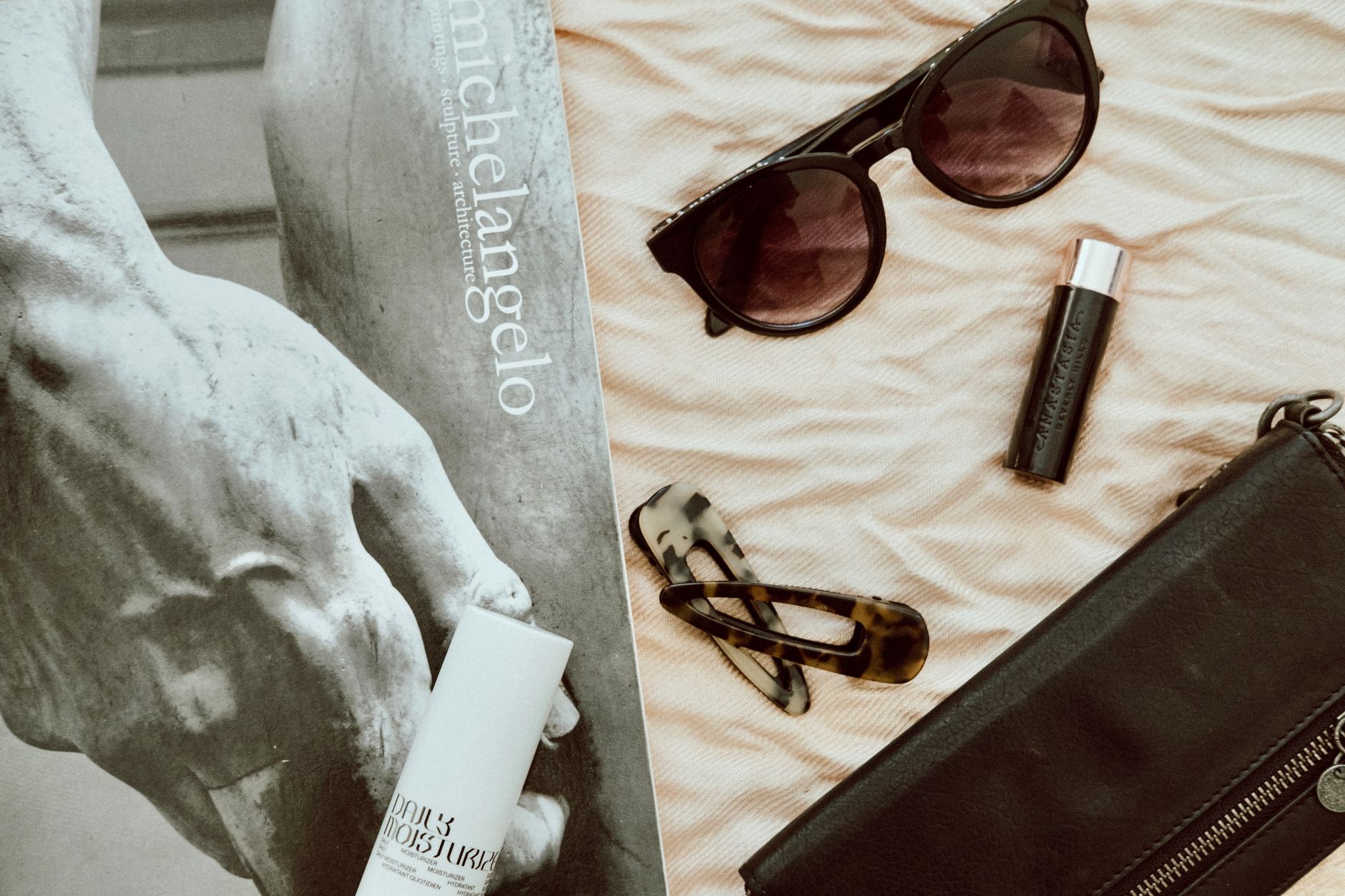 Stylish fashion accessories on display with a Michelangelo artwork in the background, creating a chic flat lay. — 4 Effective