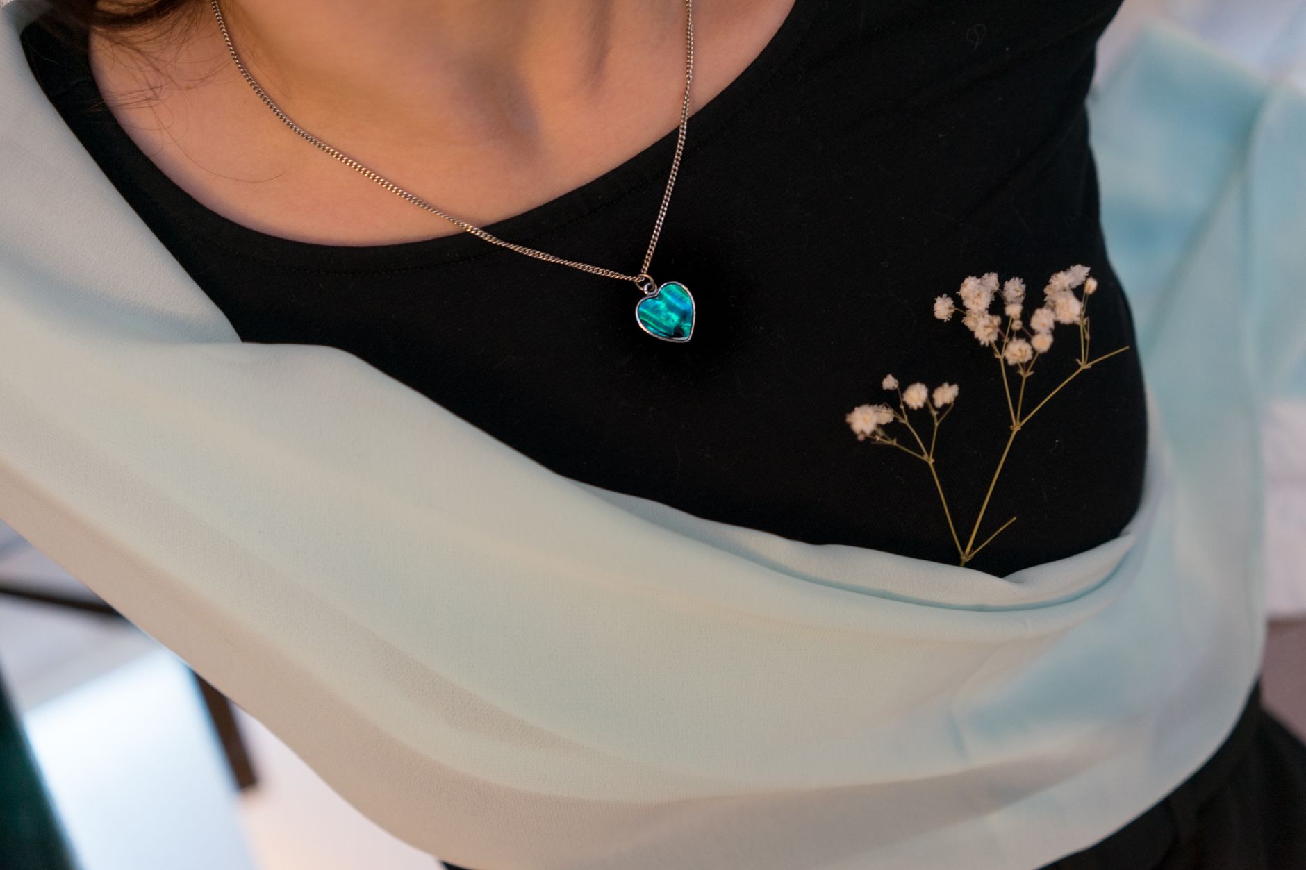 Crop anonymous female with pendant in form of heart and dried twig with delicate flowers — 5 Timeless Jewelry Pieces to Start