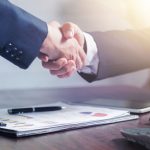 Professional handshake agreement over business charts in an office setting. — ABS Plastic Delivering Impact-Resistant Enginee