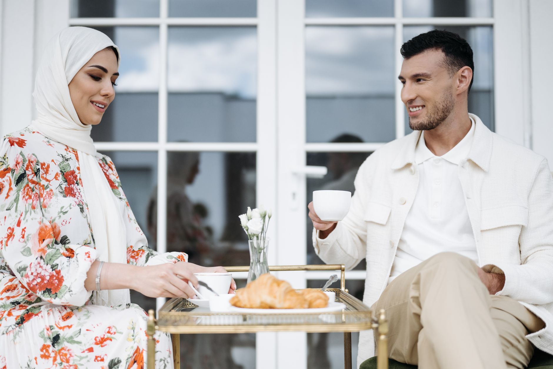 A couple sharing a joyful breakfast outdoors with coffee and croissants. — All Change Is Life-style Change