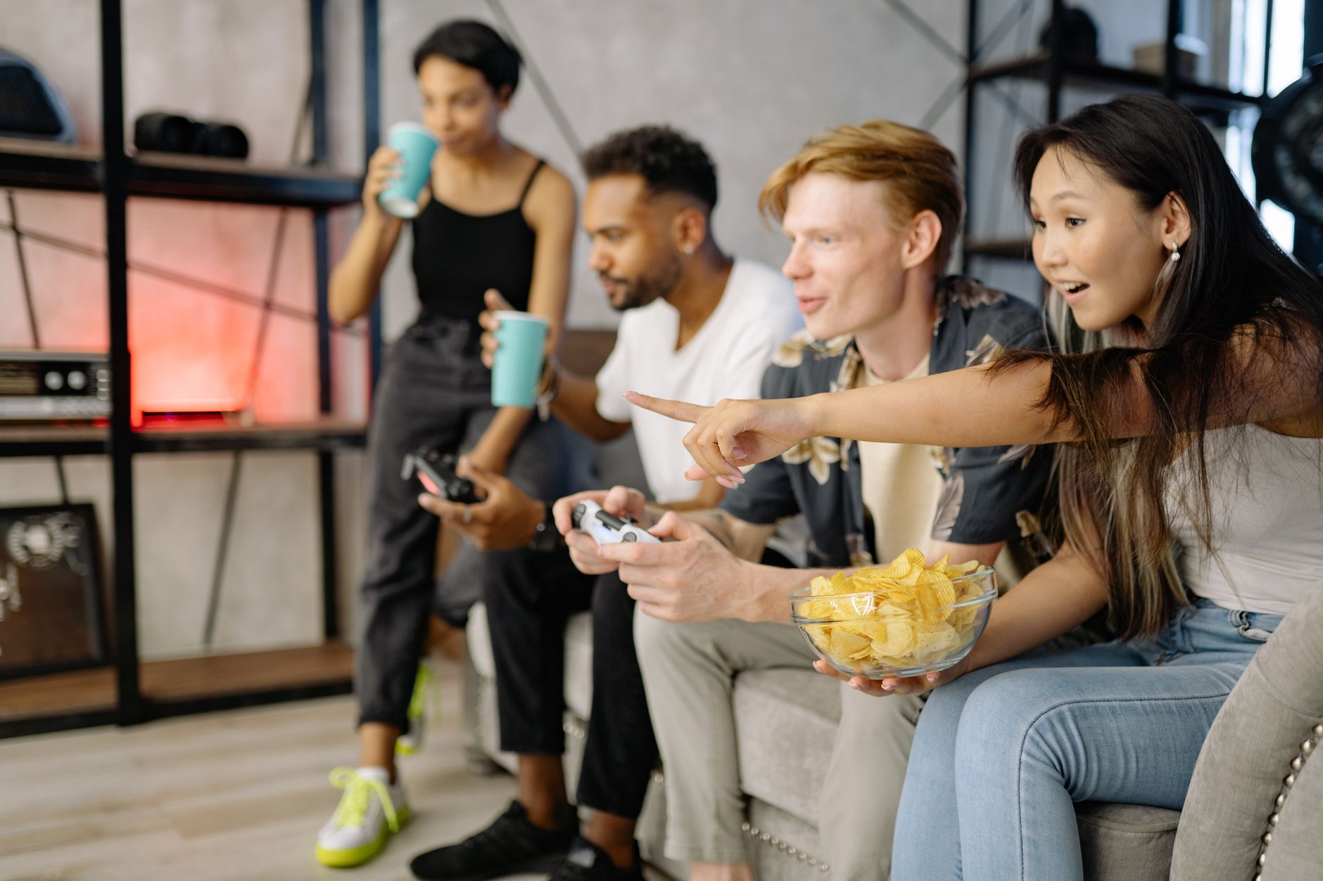 Diverse group of friends enjoying video games and snacks in a cozy living room setting. — Experience the Thrill of Web Slots