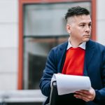A serious man holding papers, dressed professionally in an urban environment. — Exploring MT4 for MacOS Installation and Its