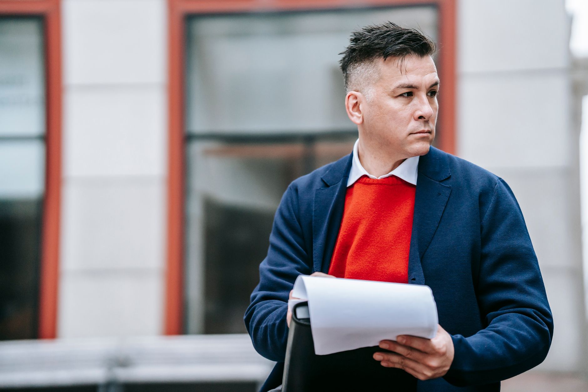 A serious man holding papers, dressed professionally in an urban environment. — Exploring MT4 for MacOS Installation and Its