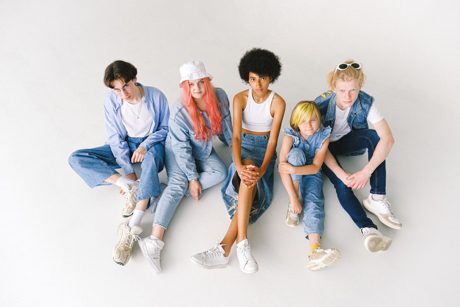 From above full body of diverse models wearing stylish denim outfits sitting on white floor in studio — Hair Care Guide For M