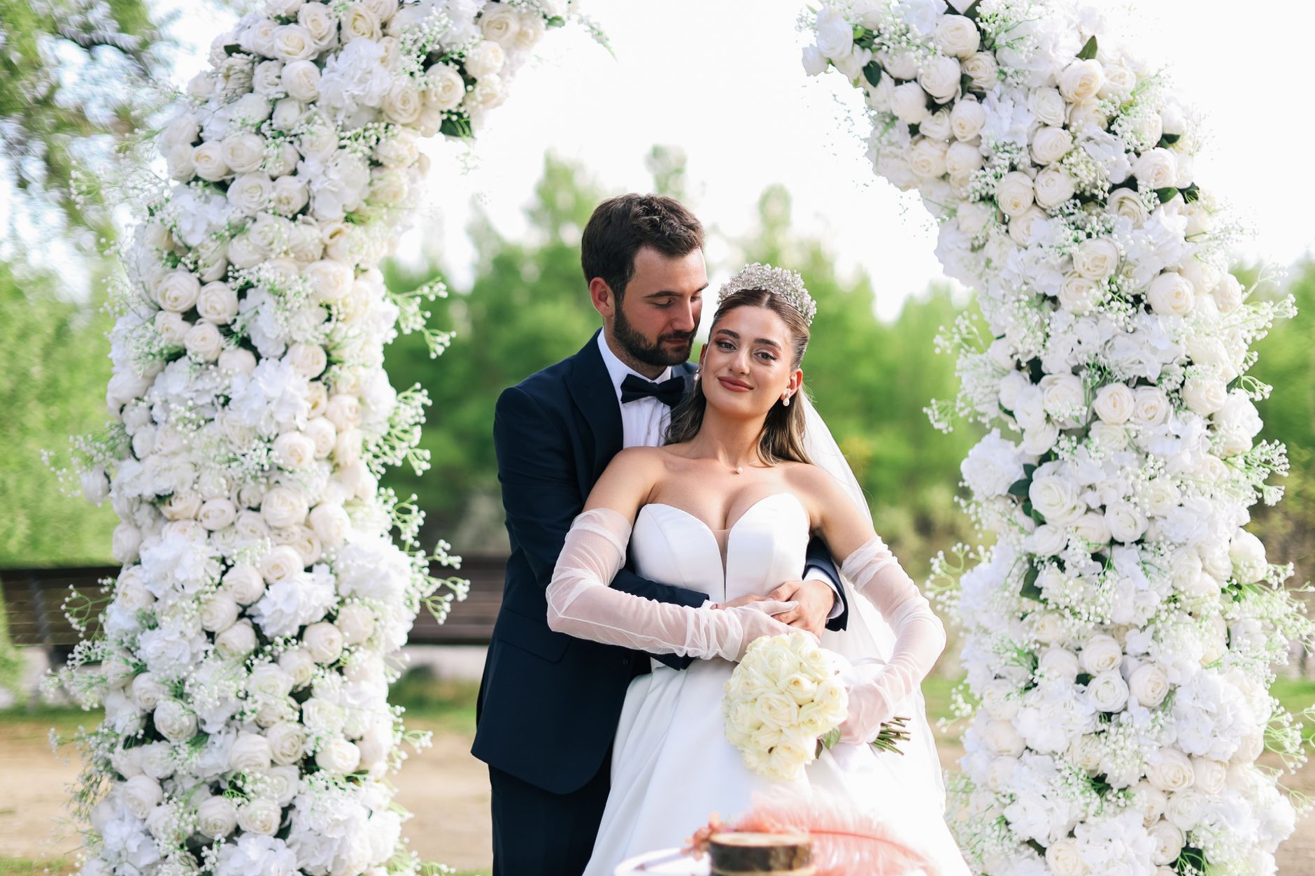 Beautiful outdoor wedding with a couple under a floral arch, captured in natural light. — Hire Expert Photographers To Captur