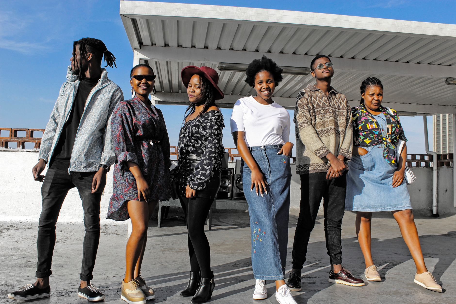 Stylish young adults in diverse fashion posing together on a rooftop under a sunny sky. — Payal designs: How to buy the right