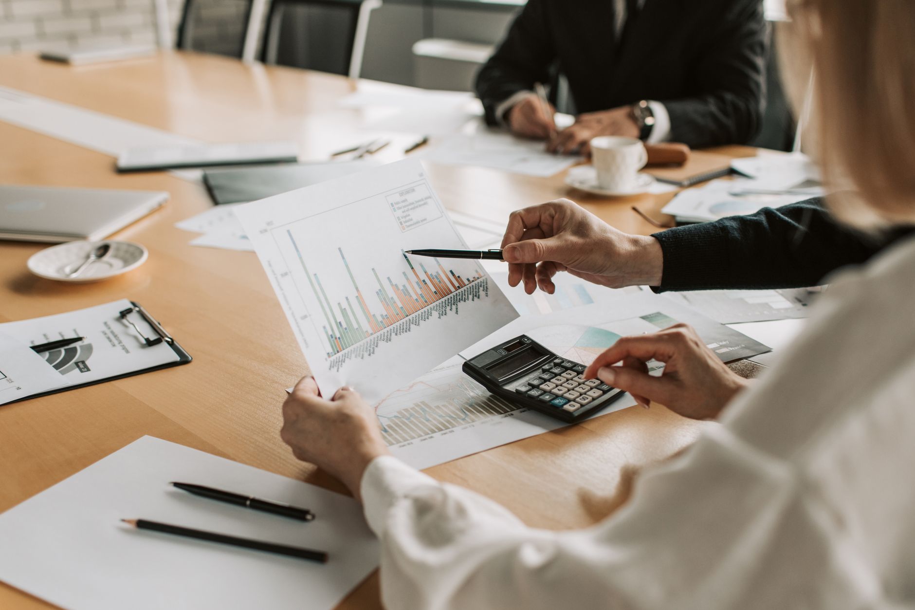 Professionals reviewing financial graphs and charts during a meeting. — Plan To Successfully Set Up a Luxury Beauty Salon