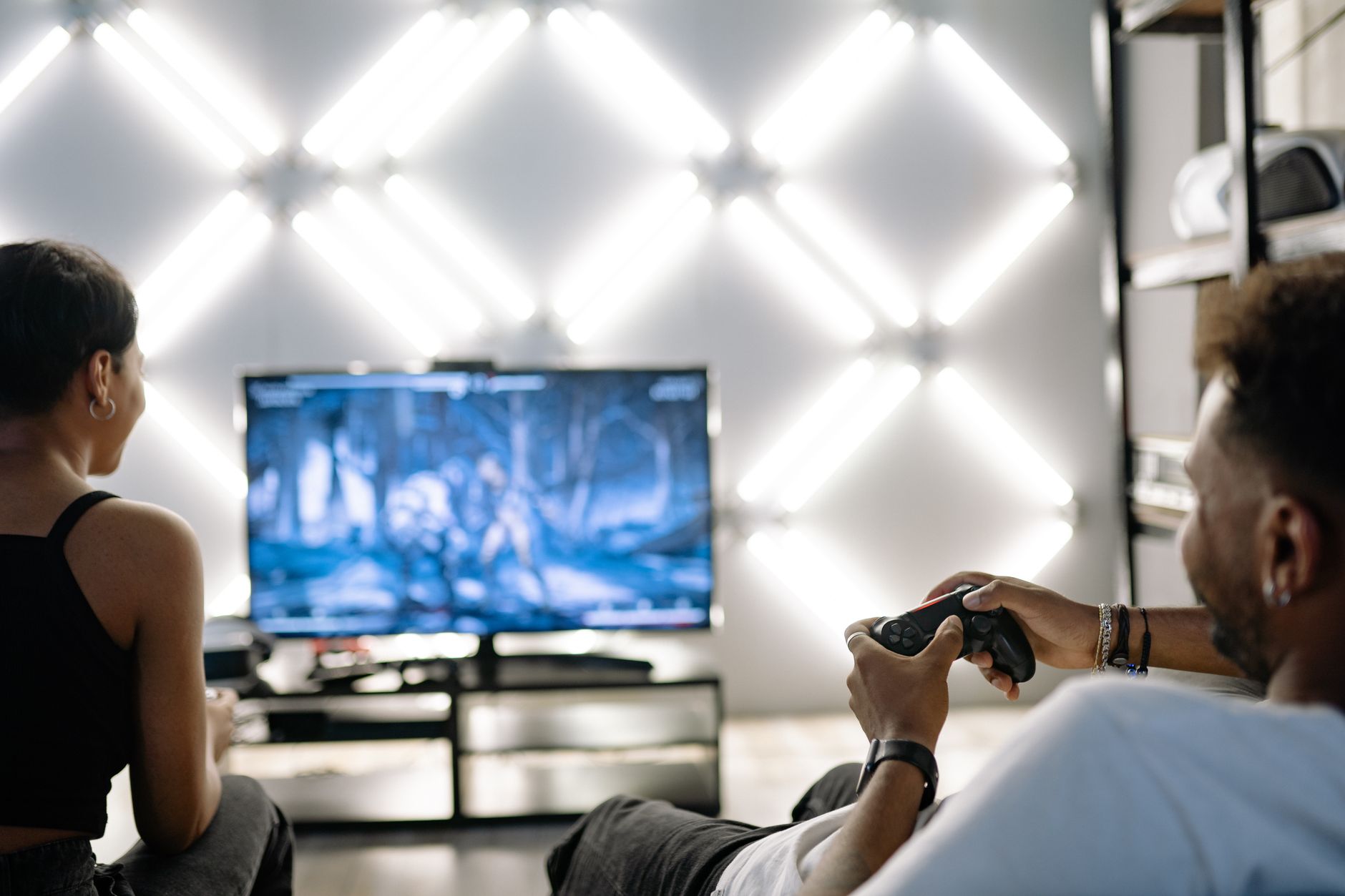Two adults are having fun playing video games in a stylish, modern living room with LED lighting. — The Best Online Sportsboo