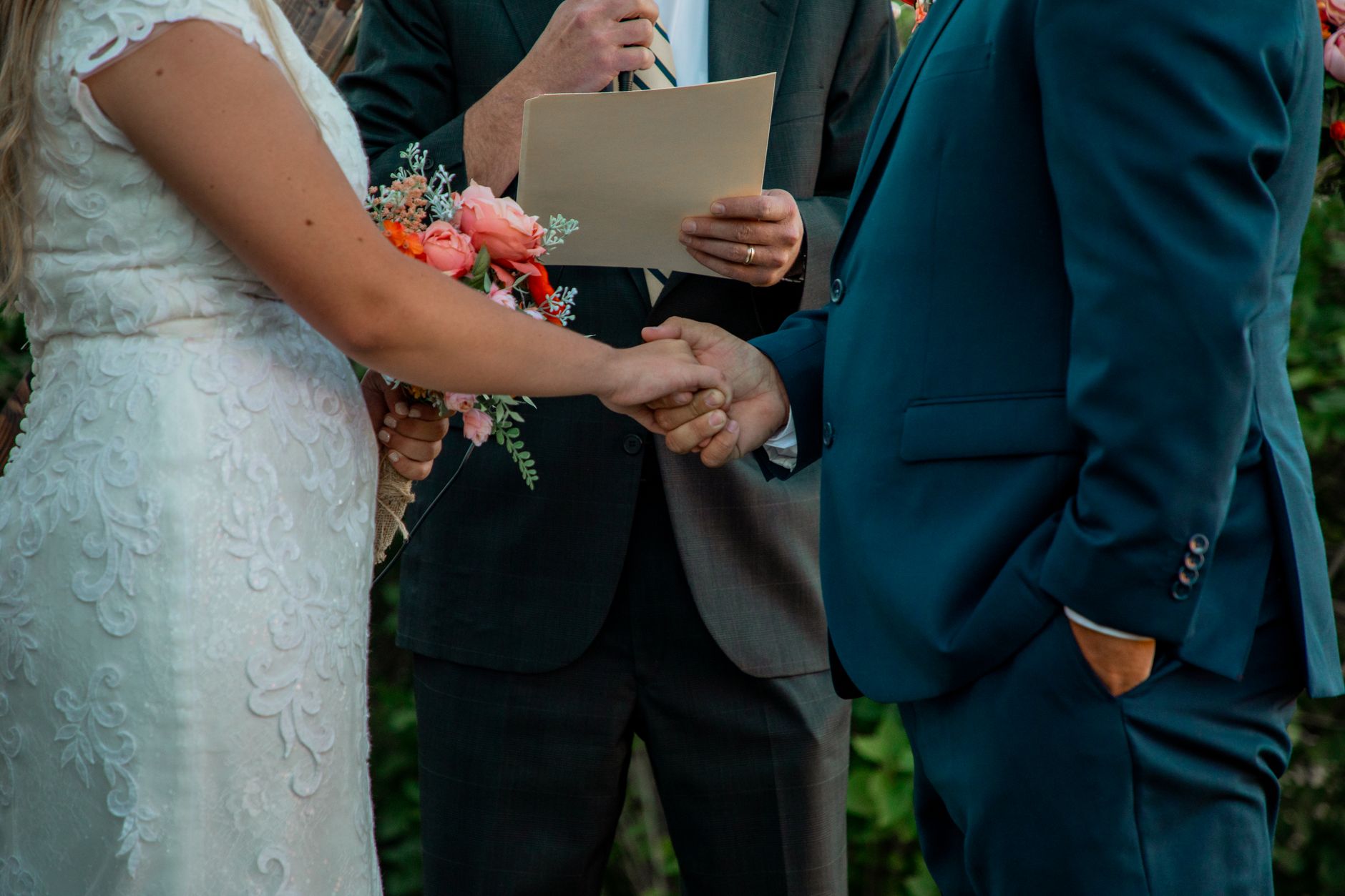 Bride and groom holding hands during outdoor wedding ceremony. — Tips and Tricks for Creating the Perfect Wedding Seating Cha